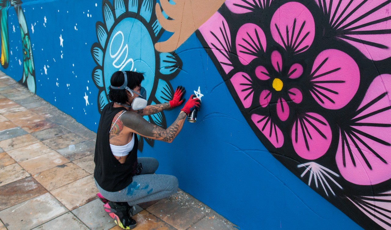 artista grafitando um muro